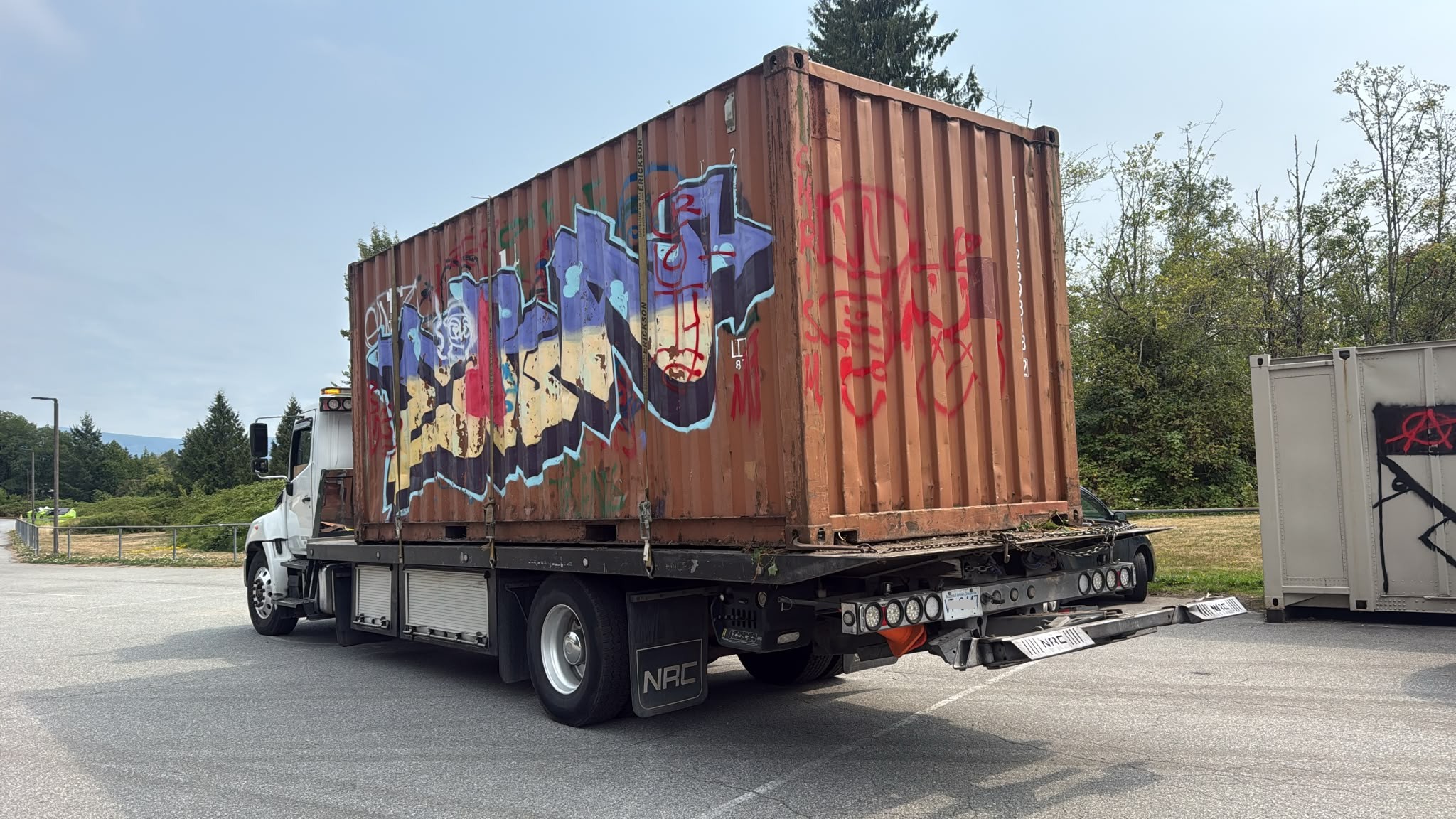 Rusted junk sea can loaded onto a truck for scrap removal in BC